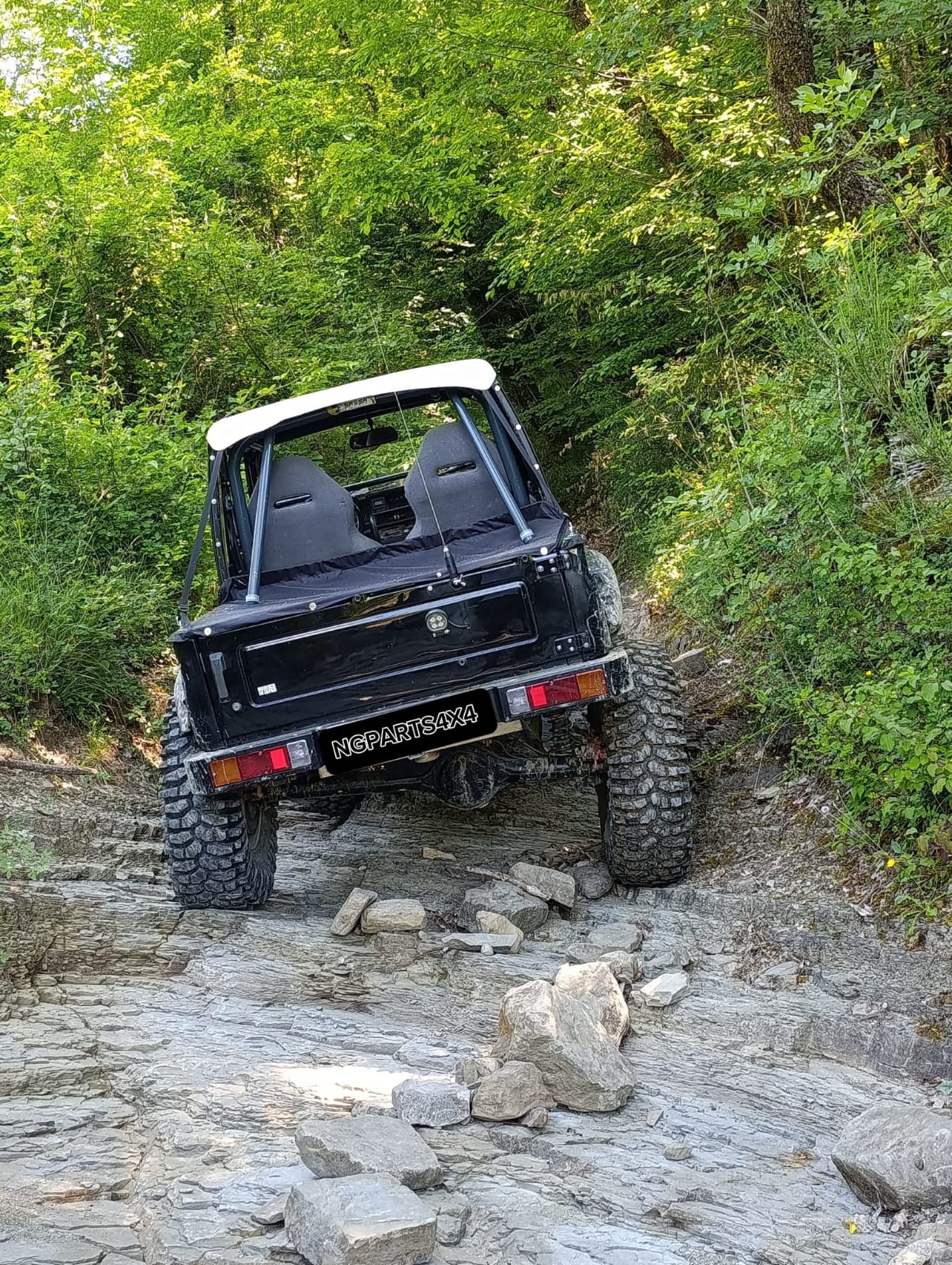 Suzuki Samurai in fuoristrada su un sentiero di roccia nel bosco